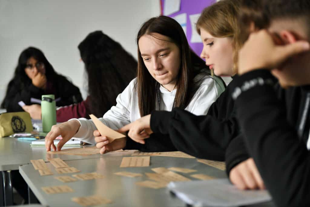Learners working on a table based activity in a classroom.
