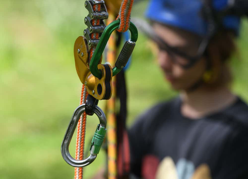 Close up of tree climbing equipment with learner in the background.