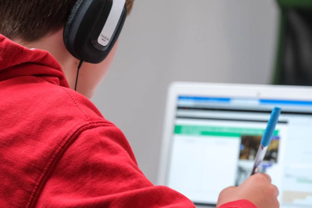 A learner using a laptop computer with headphones on.