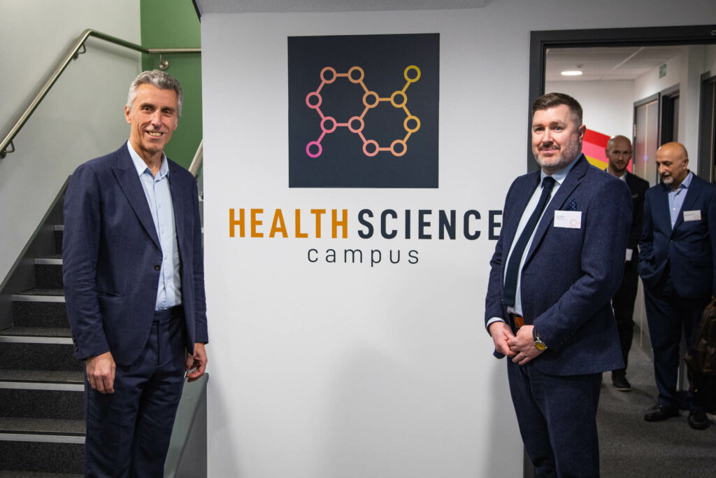 Alan Pease posing with guest at the campus launch event