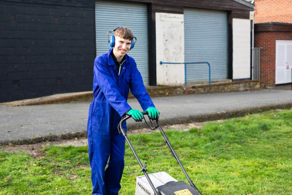 Learner Using A Lawn Mower On Campus