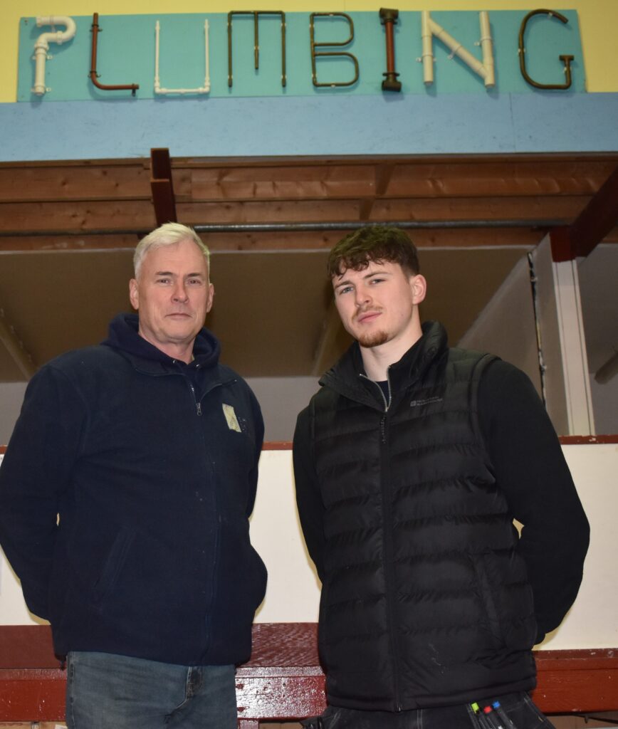 Tutor and learner in plumbing workshop
